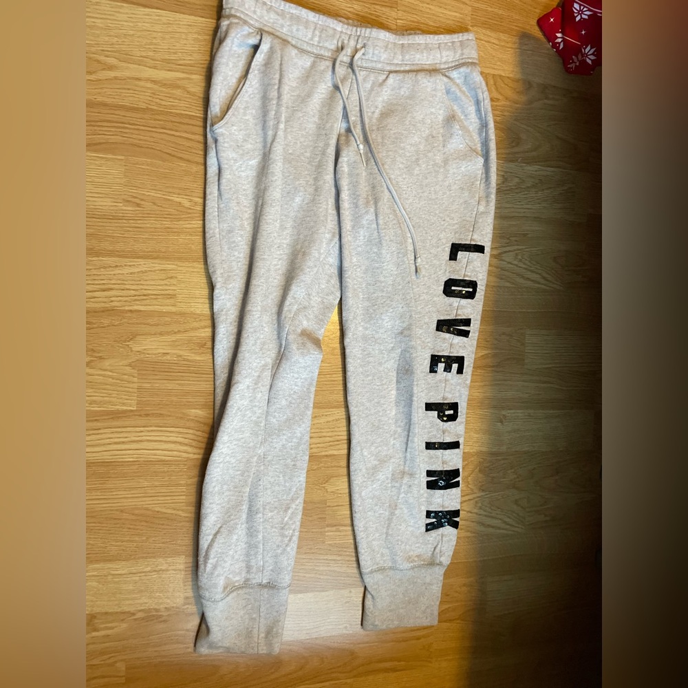 Pink sweatpants with cuffed ankle and sequence writing.